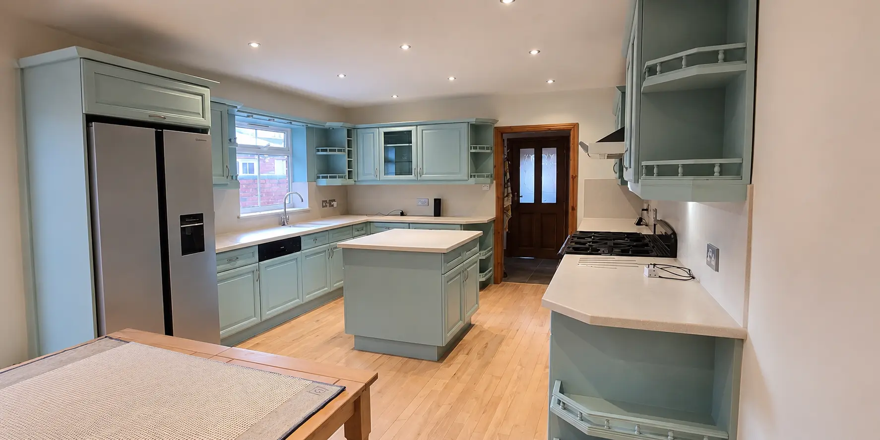 A kitchen resprayed in a soft sage green by Cutting Edge Spraying